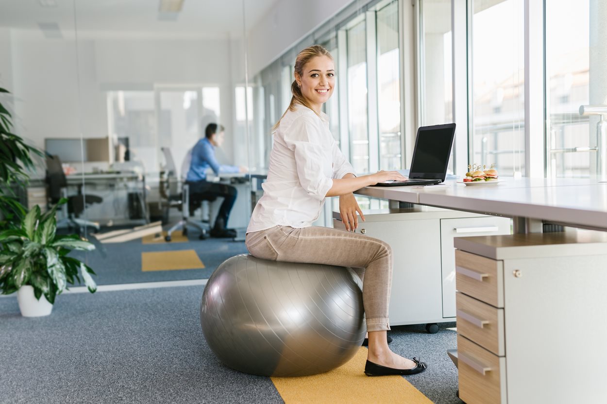 Business_woman_sitting_on_pilates_ball.jpg