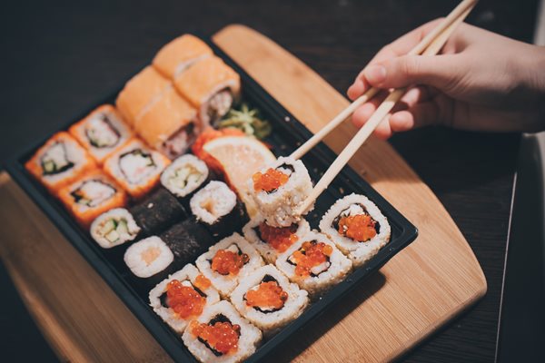 Set-sushi-set-Hand-with-chopsticks-for-sushi-_shutterstock_527851219.jpg